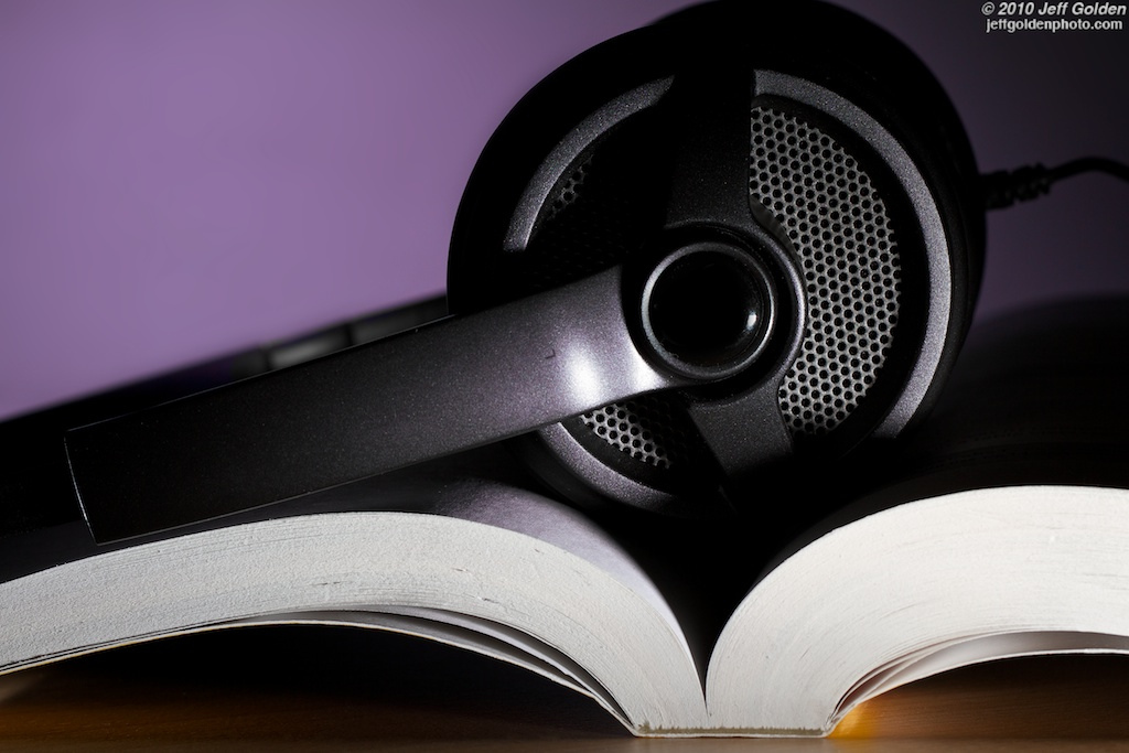 Book with headphones sitting on top